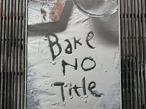 Bức tường quảng cáo 'Bake No Title' viết nguệch ngoạc trên nền bột mì giả, trang trí mặt tiền tiệm kiểu công nghiệp Hàn Quốc