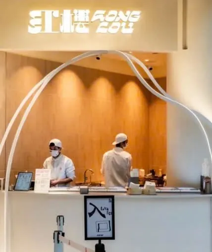 Quầy 红楼 HONGLOU gelato: chữ 红楼 HONG LOU trắng phía trên, quầy gỗ ánh đèn cam, hai nhân viên đội mũ trắng phía sau