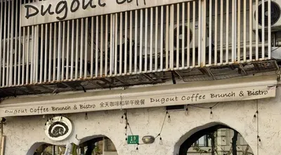 Mặt tiền trắng của Dugout tại 福州路19-2号: băng rôn 'Dugout Coffee Brunch & Bistro 全天咖啡和早午晚餐', biển số nhà xanh số 13 và hai vòm cửa đen (ảnh cắt từ bài An gửi)