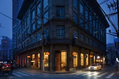 Góc tòa nhà 申报馆 lúc chập tối, biển đèn THE PRESS CAFE & RESTAURANT trên lối vào ở đường 汉口路 (ảnh trang chính thức của The Press)