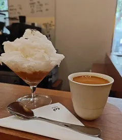 Ly đá bào trên nền cà phê và tách espresso cạnh khăn giấy in logo 3½ (ảnh An gửi)