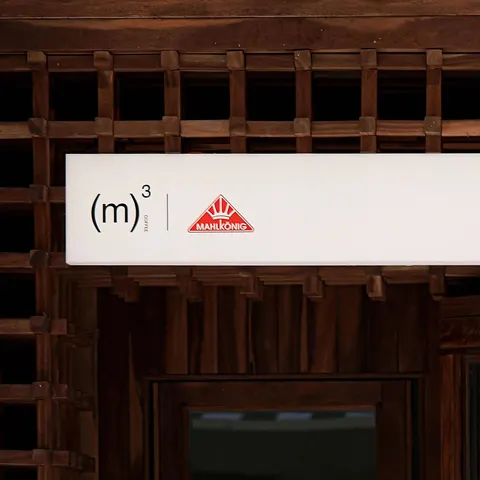 Bảng hiệu '(m)³ COFFEE × MAHLKÖNIG' trên quầy gỗ tại 三立方丨Mahlkönig Dirty专门店