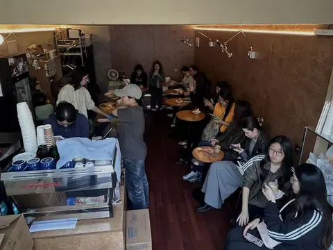 Không gian bên trong Honky Tonk Coffee thấp hơn mặt phố, tường đồng ấm áp và sàn gỗ, khách ngồi kín các bàn nhỏ