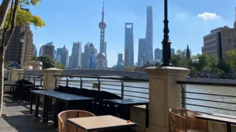 Sân hiên gỗ ven sông Tô Châu của 汭REi·FLOWER COFFEE BAR, bàn ghế mây nhìn sang tháp Đông Phương Minh Châu