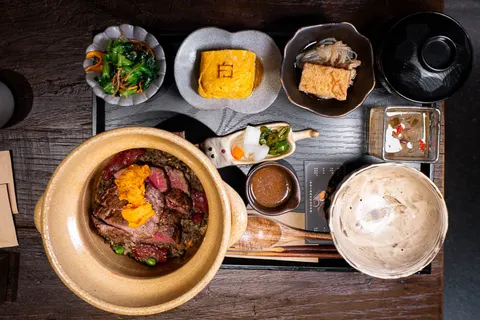 Set cơm niêu bò wagyu của White Foods: niêu đất cơm bò, đậu Hà Lan, kèm canh, dưa muối và nước sốt