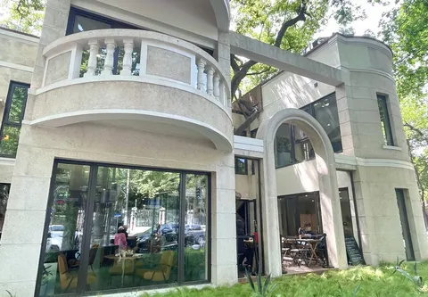 Mặt tiền biệt thự trắng kiểu châu Âu của Yichi Garden trên đường Hành Sơn, ban công vòm cong và cây xanh bao quanh