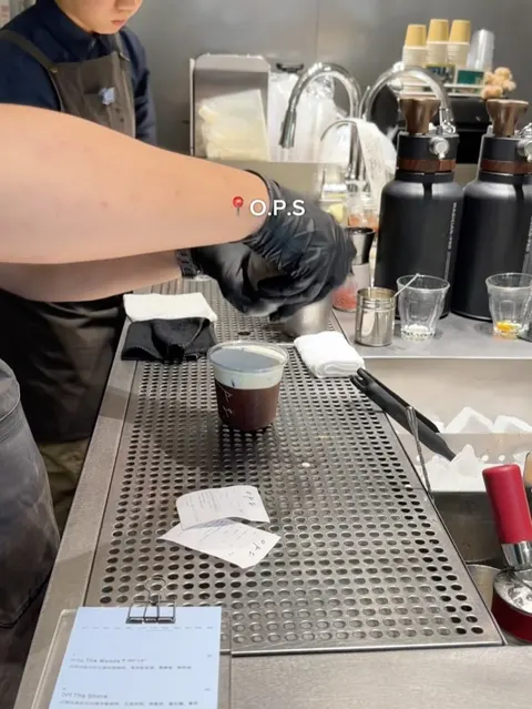 Barista tại O.P.S. đang rót cà phê, ảnh có gắn nhãn địa điểm 📍 O.P.S từ bài Instagram gốc