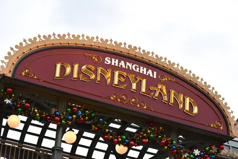 Biển hiệu cổng vào SHANGHAI DISNEYLAND chữ vàng trên nền đỏ đô, trang trí vòng hoa Giáng sinh