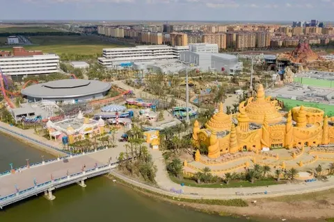 Toàn cảnh trên cao công viên Haichang Ocean Park Thượng Hải với các toà lâu đài chủ đề màu vàng, tàu lượn và hồ nước bao quanh