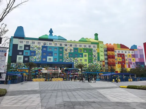 Cổng vào LEGOLAND Shanghai Resort với biển hiệu lớn, toà nhà ốp mảng màu như khối Lego phía sau