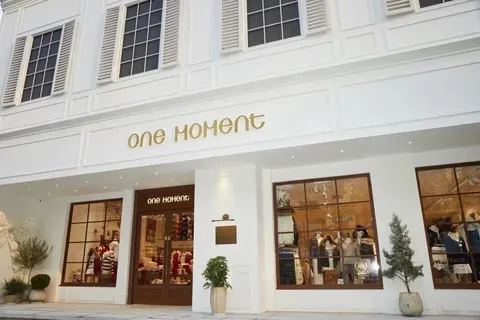 Mặt tiền trắng chữ vàng 'one MOMENT' của tiệm flagship ONE MOMENT ở 淮海百盛 (đường Hoài Hải, Thượng Hải) — tiệm khác, không phải tiệm GATE M (ảnh: 赢商网)