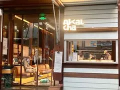 Mặt tiền AKALCHA trên đường Vĩnh Nguyên Lộ với biển hiệu Akal cha và khu ghế ngồi ngoài trời