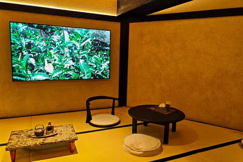 Phòng chiếu riêng kiểu tatami ở tầng trên, màn hình chiếu cảnh đồi trà xanh, bàn thấp và nệm ngồi kiểu Nhật
