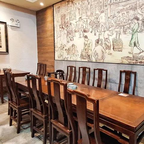 Phòng ăn của 大壶春 chi nhánh 四川中路, bàn ghế gỗ và tranh tường cảnh phố Thượng Hải xưa