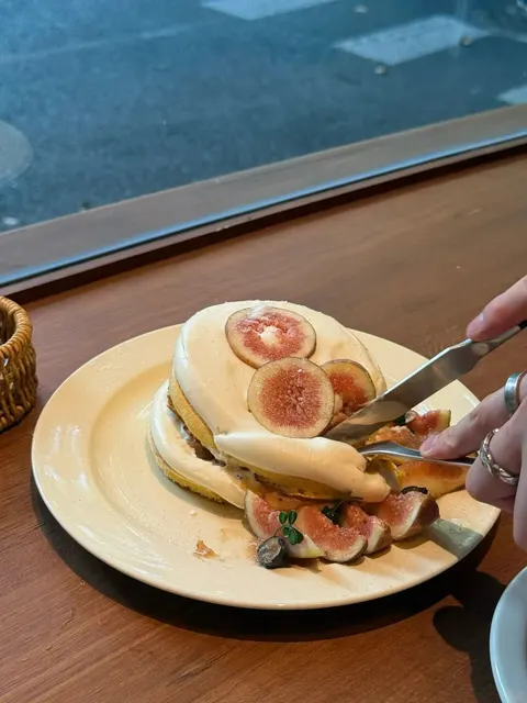 Chồng pancake soufflé phủ kem và quả sung tươi trên đĩa vàng