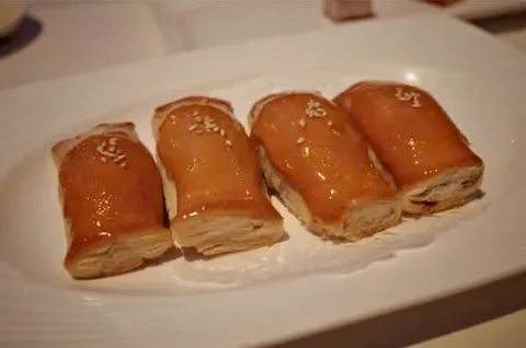 Bốn chiếc bánh cuốn vỏ nướng vàng bóng, mặt rắc mè, cắt lộ nhân (ảnh An gửi)