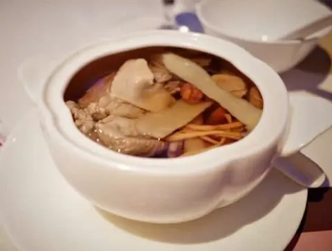 Thố sứ trắng đựng canh hầm có thịt, lát củ và thảo mộc (ảnh An gửi)