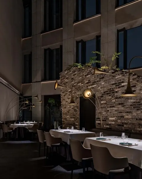 Khu ăn sát vách gạch xám mô phỏng tường thành cổ, đèn hình kèn đồng cổ điển và cây tùng la hán