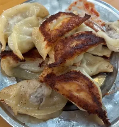 Cận cảnh đĩa 煎饺 lật ngửa thấy đáy chiên vàng nâu, vỏ mỏng; ảnh không cho biết chi nhánh (ảnh An gửi, 08/10)