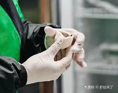Nhân viên quán đang nặn tangyuan bằng tay, đeo găng tay bảo hộ