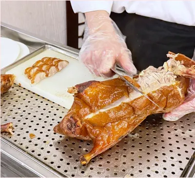 Đầu bếp đang lọc vịt quay nguyên con ngay tại bàn ở 全聚德, da vịt vàng bóng giòn