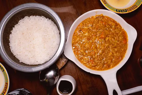 蟹粉捞饭: nồi cơm trắng bằng kim loại cạnh đĩa gạch cua sánh màu cam