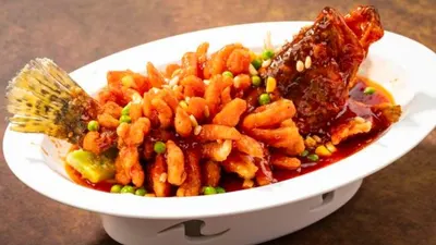 Món 松鼠鲈鱼: cá chiên giòn khía hình con sóc, rưới sốt chua ngọt đỏ cam, rắc đậu Hà Lan và hạt thông (ảnh trang Trip.com của chi nhánh 外滩南京路店, 九江路80号)