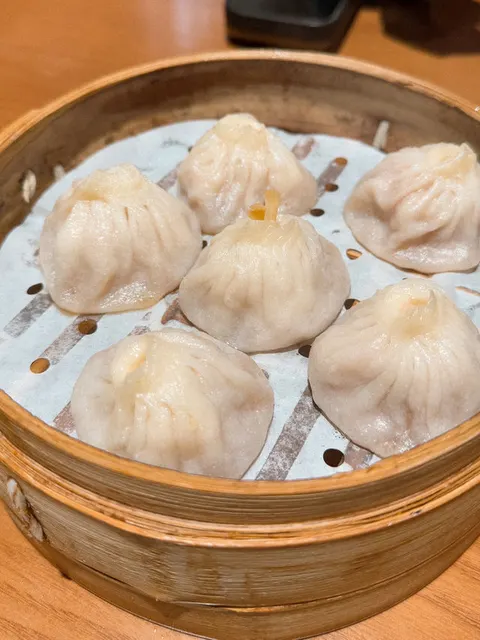 Sáu chiếc tiểu long bao gạch cua trong xửng tre, da bánh mỏng trong suốt thấy rõ nhân cua bên trong