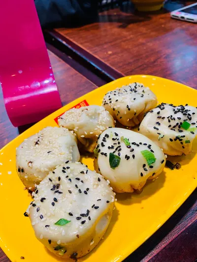 Đĩa 6 chiếc sinh tiền nhiều vị (三拼生煎) rắc vừng đen, vừng trắng và hành lá — ảnh khách trên Dianping, chụp tại 小杨生煎 宁波路店